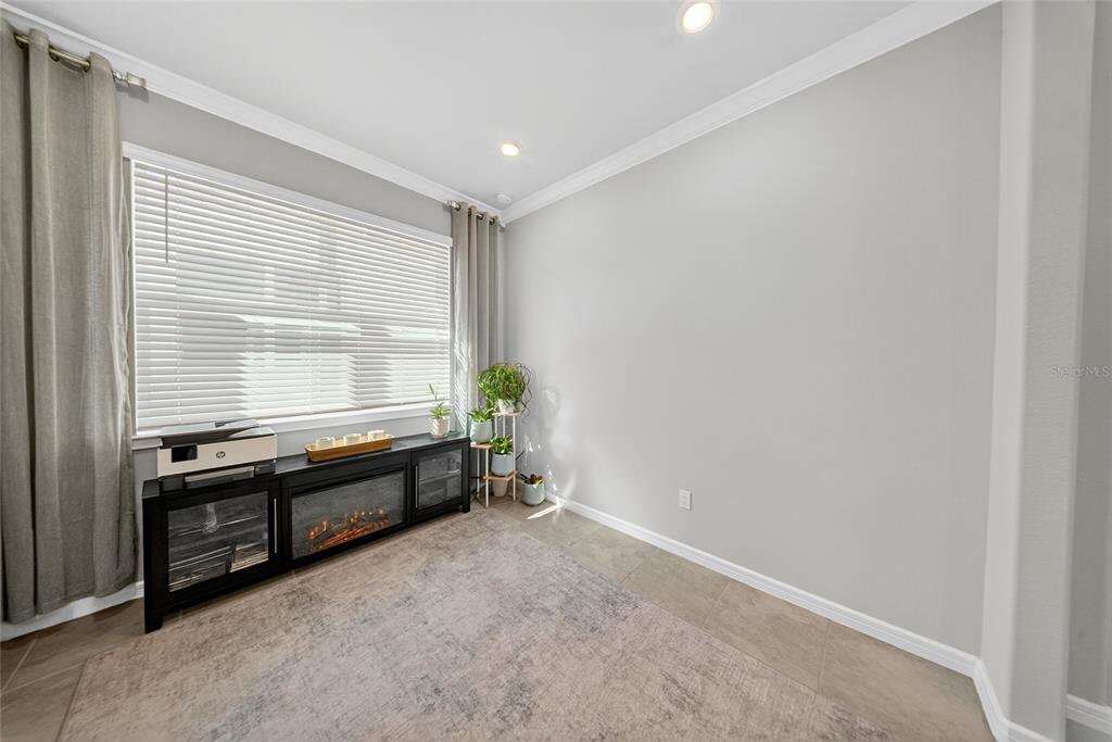 An open-concept living and dining area features tile flooring, a sectional sofa, and sliding doors — 1845 SPRING SHOWER CIRCLE, KISSIMMEE, FL