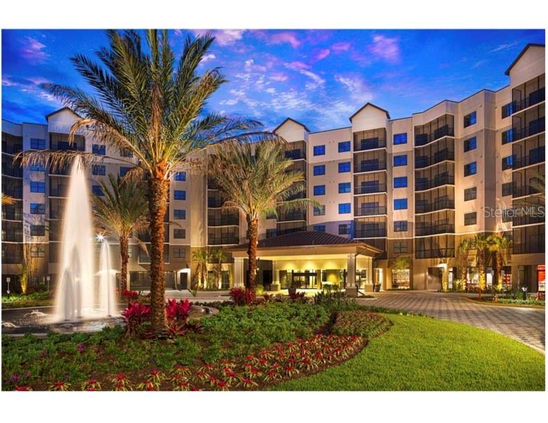 A multi-story apartment building features a fountain in the foreground and a covered entrance — 14501 GROVE RESORT AVENUE UNIT 1237, WINTER GARDEN, FL