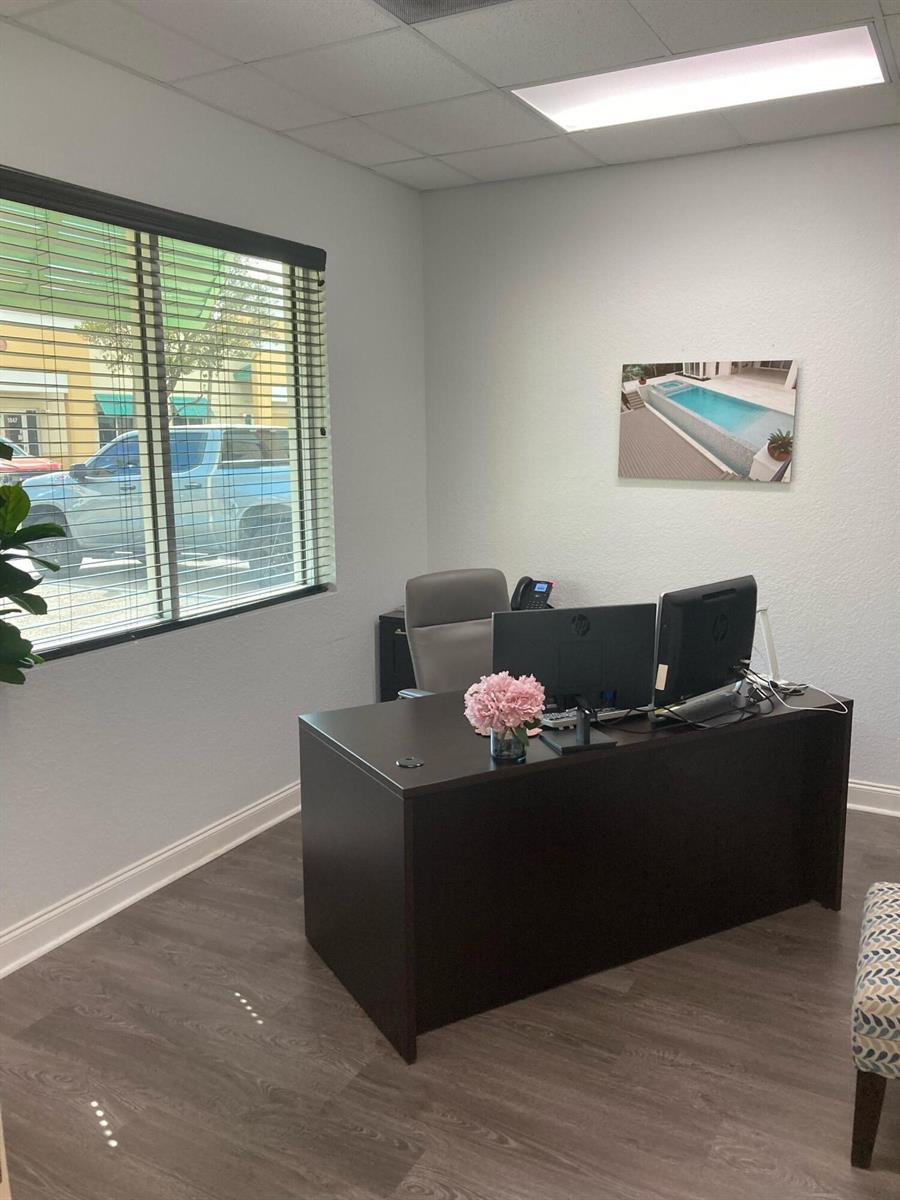 An office features a dark desk, two computer monitors, a window with blinds, and flooring — 1921 Banks Road, Margate FL 33063, MARGATE, FL