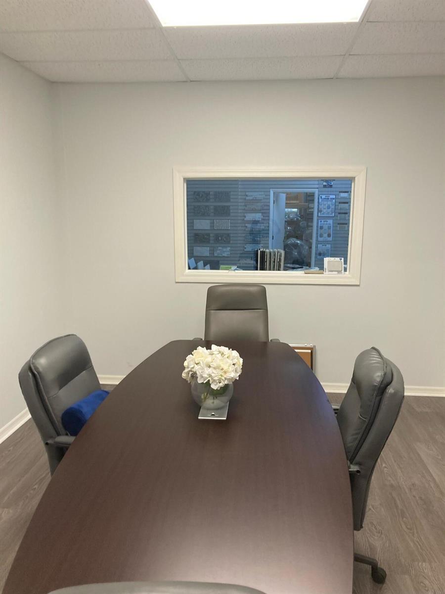 A conference room features a dark wood table, three gray chairs, and a window — 1921 Banks Road, Margate FL 33063, MARGATE, FL