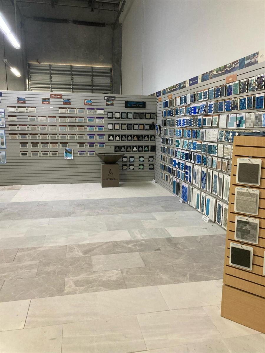 A showroom displays various tile and stone samples on wall-mounted racks and floor sections — 1921 Banks Road, Margate FL 33063, MARGATE, FL