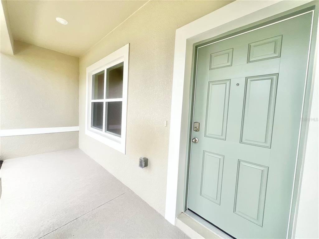 A light green front door opens onto a covered porch with a window — 101 PRITCHARD DRIVE, PALM COAST, FL
