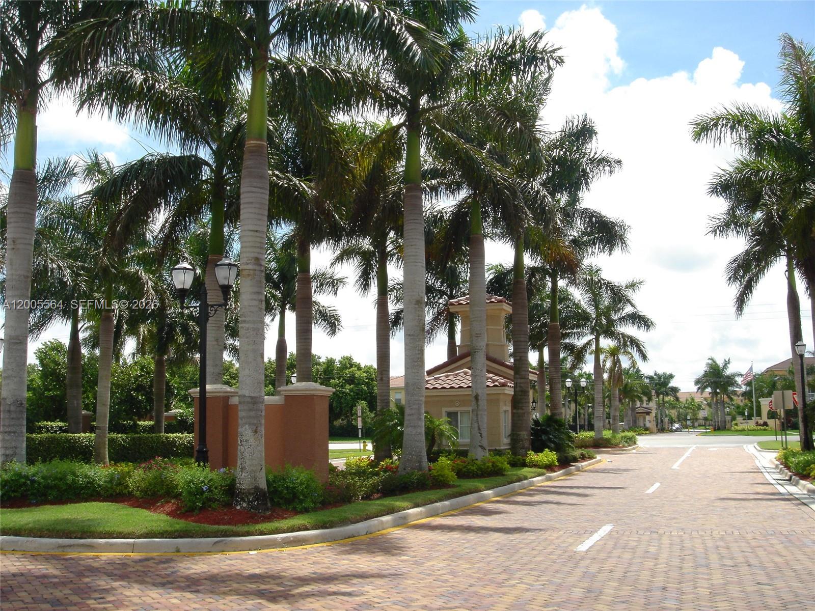 A brick driveway leads to a Mediterranean-style building entrance surrounded by tall palm trees — 4508 SW 160th Ave # 736, Miramar FL 33027, MIRAMAR, FL