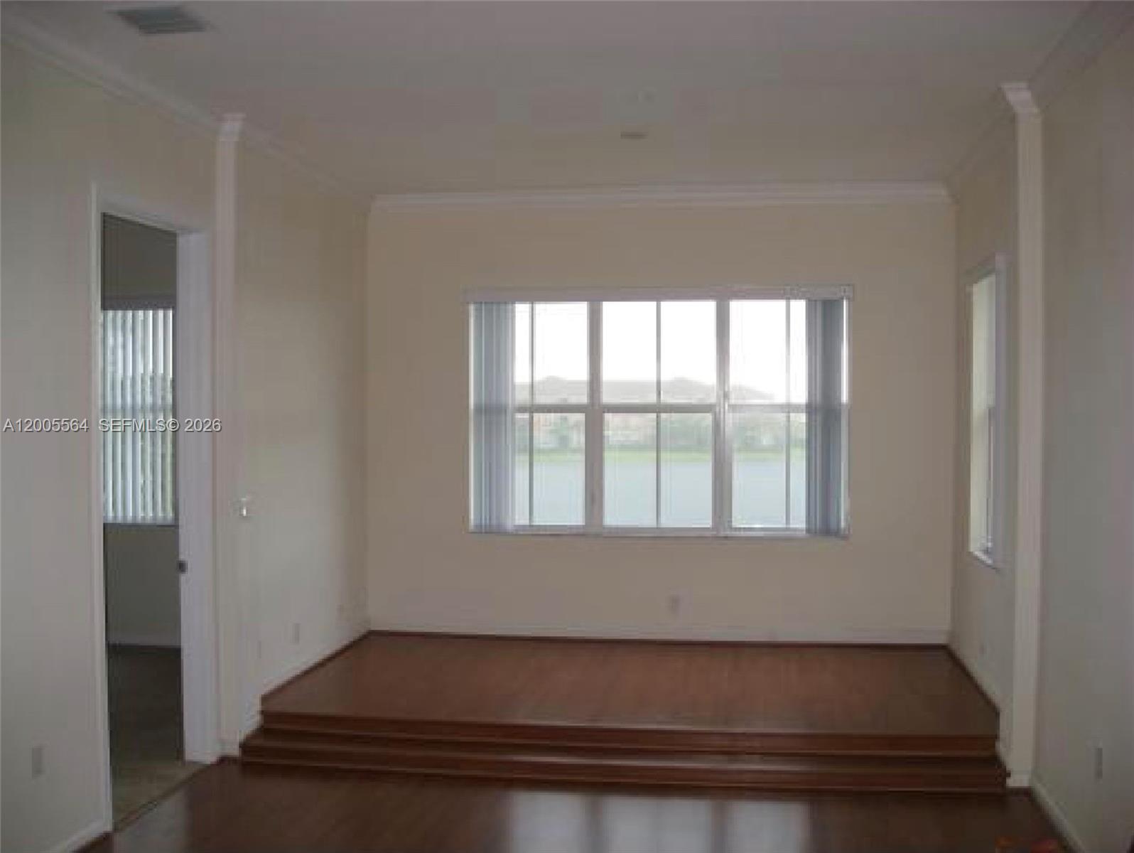 A room with a raised wooden platform area featuring a large window overlooking a lake — 4508 SW 160th Ave # 736, Miramar FL 33027, MIRAMAR, FL