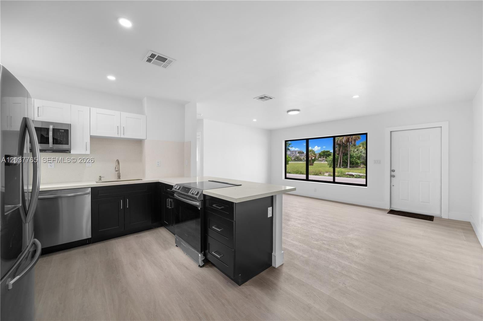 A kitchen with black lower cabinets, white upper cabinets, and a central island — 2983 NW 1st St, Pompano Beach FL 33069, POMPANO BEACH, FL