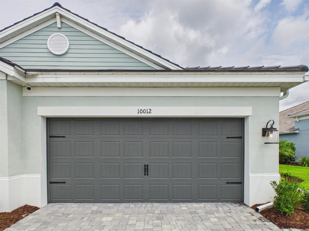 A view of the side exterior of a house with a lawn and landscaping — 10012 LAKE WALES CIRCLE, SARASOTA, FL