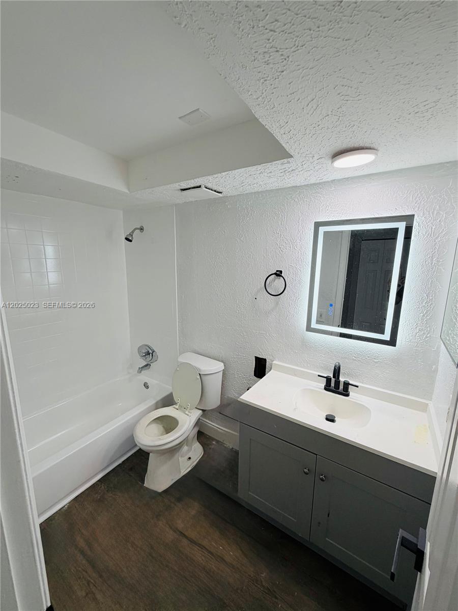 A bathroom features a white tub-shower combo, a toilet, and a gray vanity with mirror — 331 NW 42ND CT # 101, Pompano Beach FL 33064, POMPANO BEACH, FL