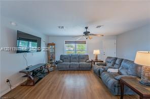 A living room features gray furniture, a wall-mounted television, and light wood-look flooring — 1500 Jay Ter, La Belle FL 33935, LA BELLE, FL
