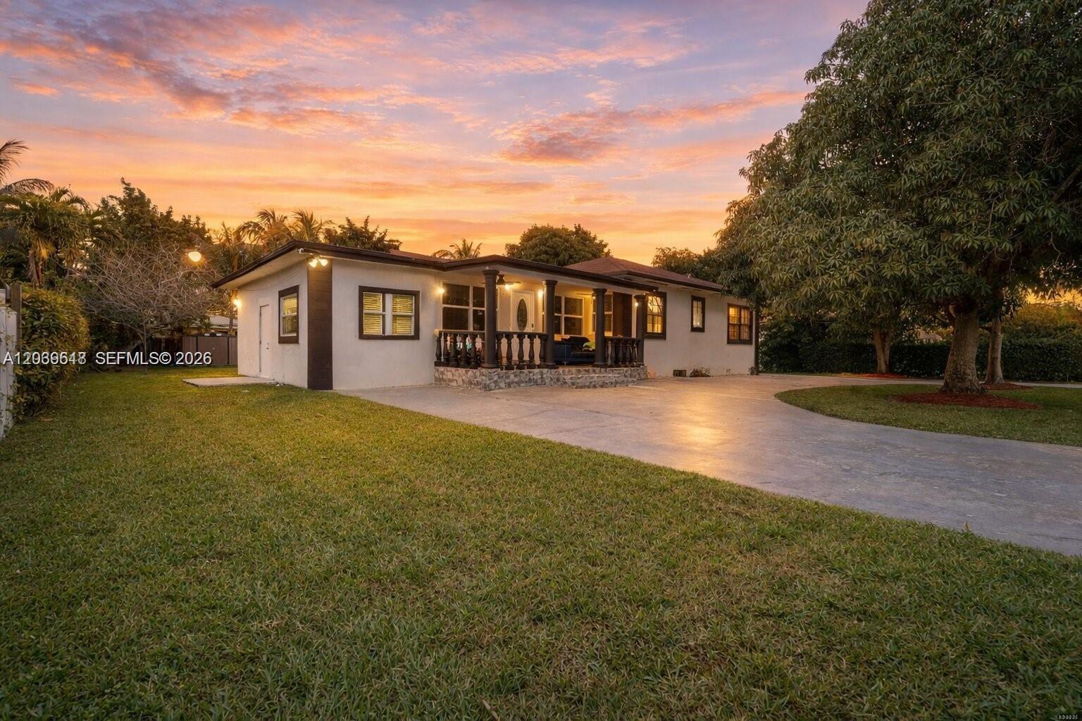 A single-story house with a concrete driveway and a covered porch at sunset — 65 NW 118th St, Miami FL 33168, MIAMI, FL