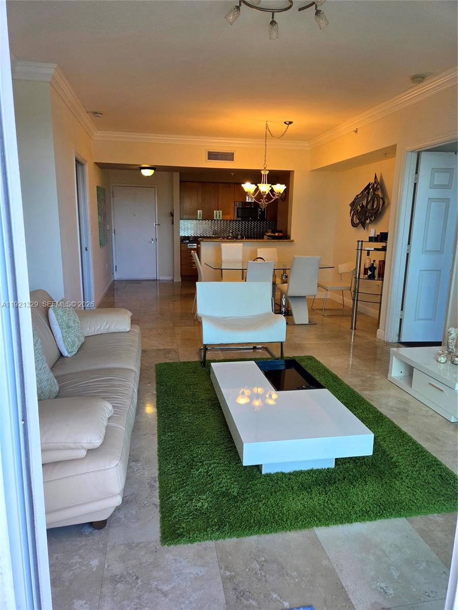 A living room and dining area feature tile floors, a green rug, and white furniture — 1755 E Hallandale Beach Blvd # 305E, Hallandale Beach FL 33009, HALLANDALE BEACH, FL