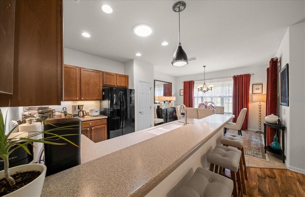 A kitchen with wood cabinets, a breakfast bar, and an adjacent dining area — 9841 SW 75TH STREET ROAD, OCALA, FL