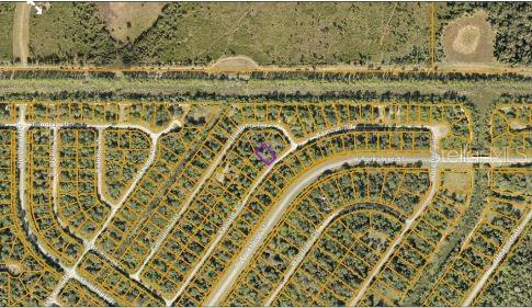 This aerial map shows a vacant residential lot outlined in purple within a suburban neighborhood — KAMAIN ROAD, NORTH PORT, FL