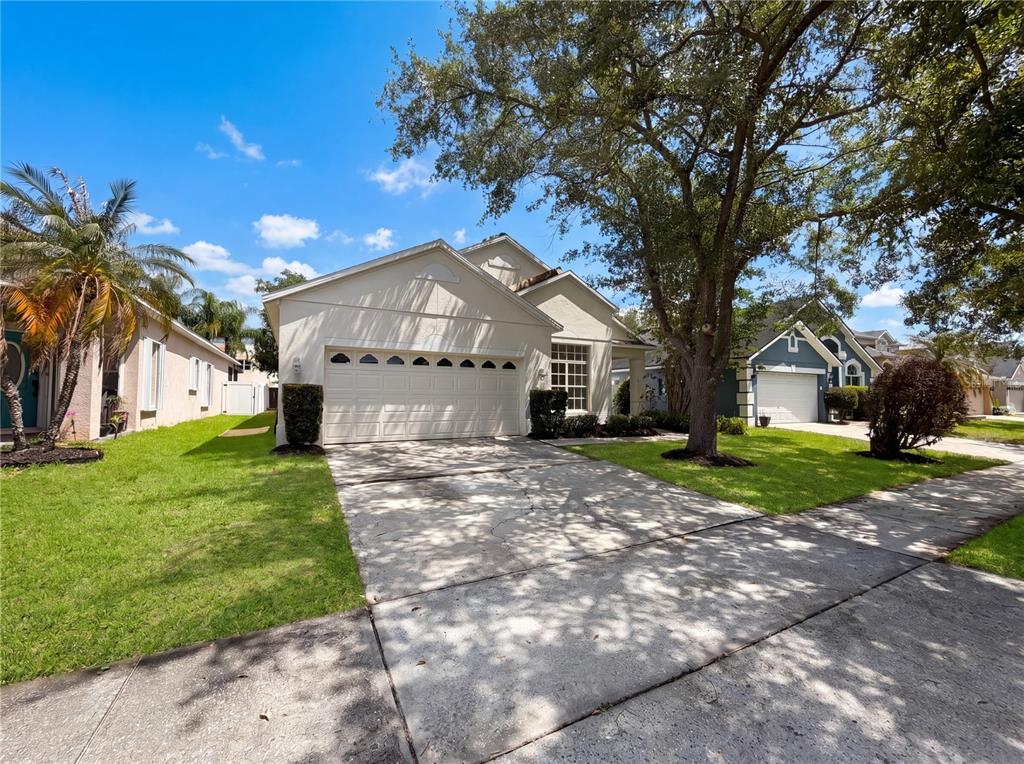 A single-story house with a beige exterior, a two-car garage, and a concrete driveway — 6202 LIGHTNER DRIVE, ORLANDO, FL