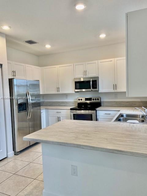 A kitchen features white cabinets, stainless steel appliances, and a light-colored countertop — 20626 NE 5th Pl # 20626, Miami FL 33179, MIAMI, FL