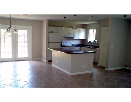 A kitchen with white cabinets, a dark island countertop, and tile flooring — 6315 Bischoff Road, West Palm Beach FL 33413, WEST PALM BEACH, FL