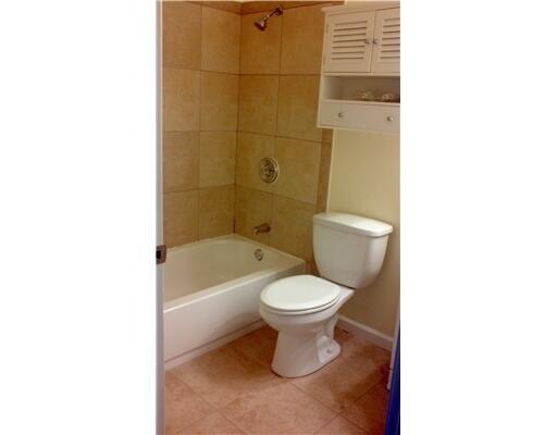 A small bathroom features a white toilet, a bathtub with tan tile walls, and wall cabinetry — 6315 Bischoff Road, West Palm Beach FL 33413, WEST PALM BEACH, FL