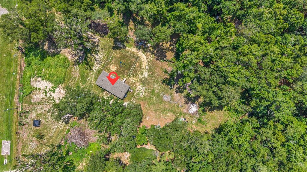 An aerial view shows a rectangular house situated on a wooded lot with cleared land — 24050 CORTEZ BOULEVARD, BROOKSVILLE, FL