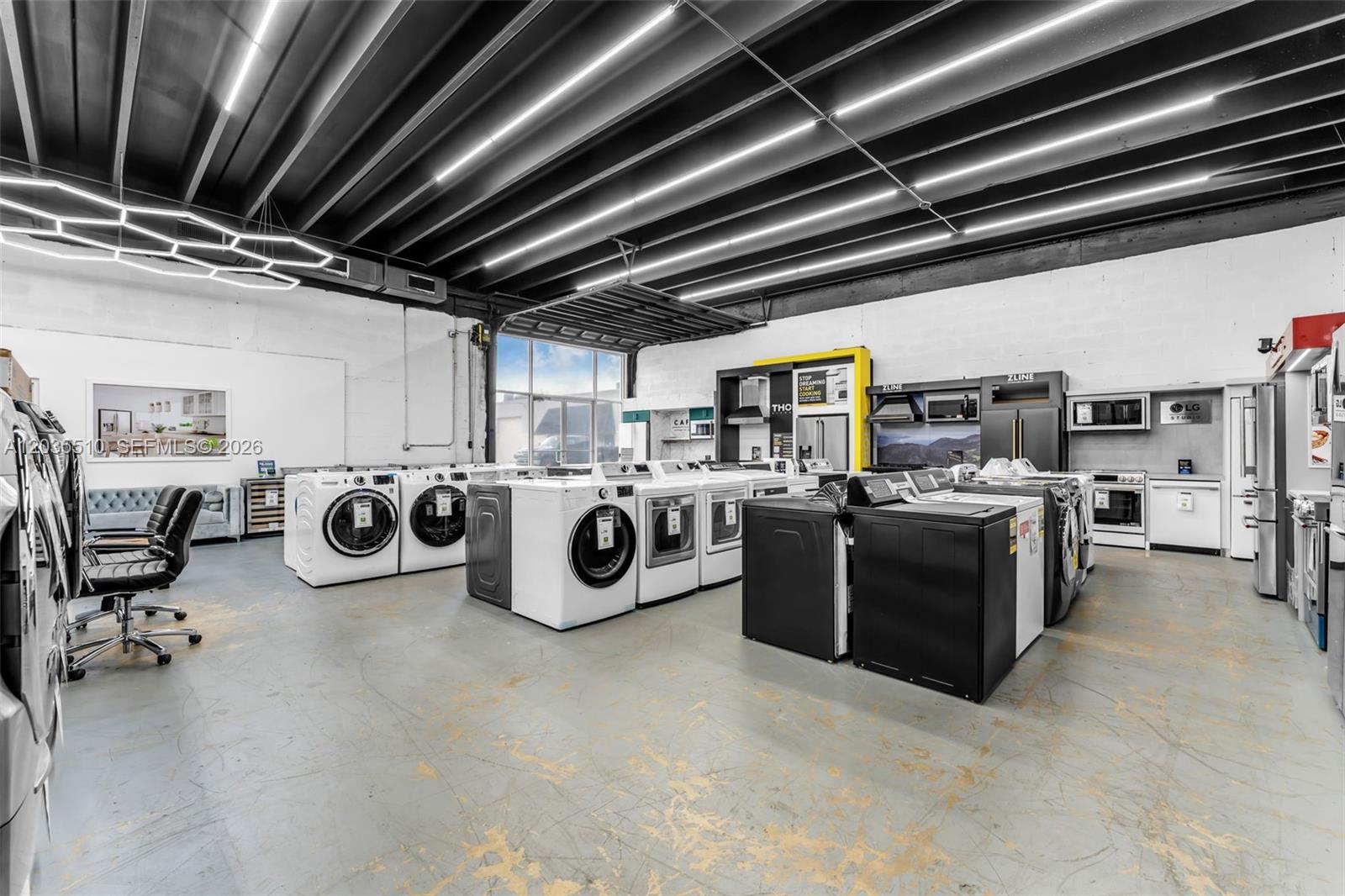 A commercial showroom displays various home appliances, including washers, dryers, and refrigerators on a concrete floor — 12134 SW 114 Place, Miami FL 33176, MIAMI, FL
