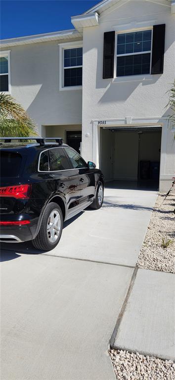 A black SUV is parked in the driveway in front of a two-story residential building — 9241 ROCK HARBOUR WAY, TAMPA, FL