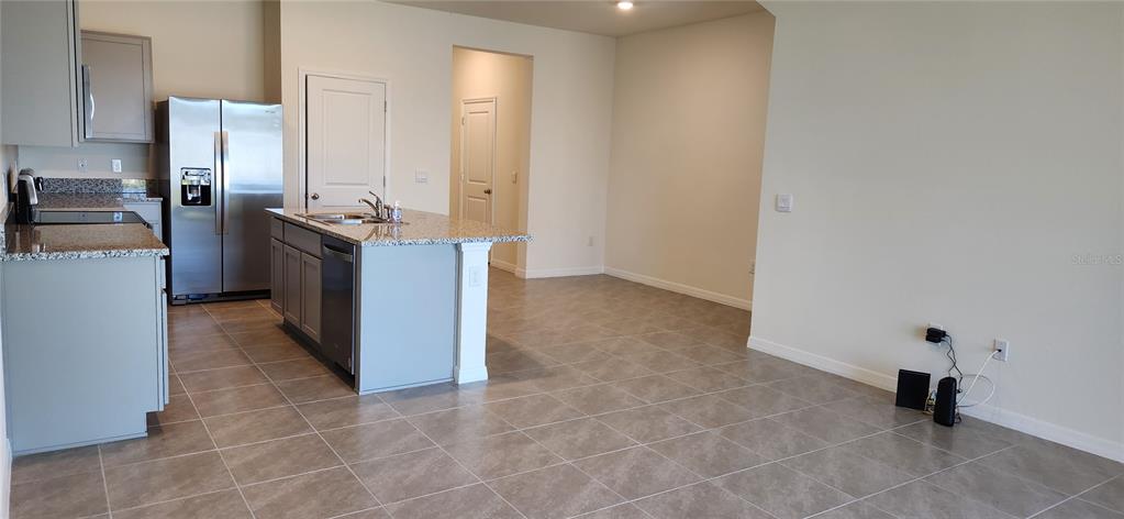 A kitchen with gray cabinets, granite countertops, stainless steel appliances, and a central island — 9241 ROCK HARBOUR WAY, TAMPA, FL