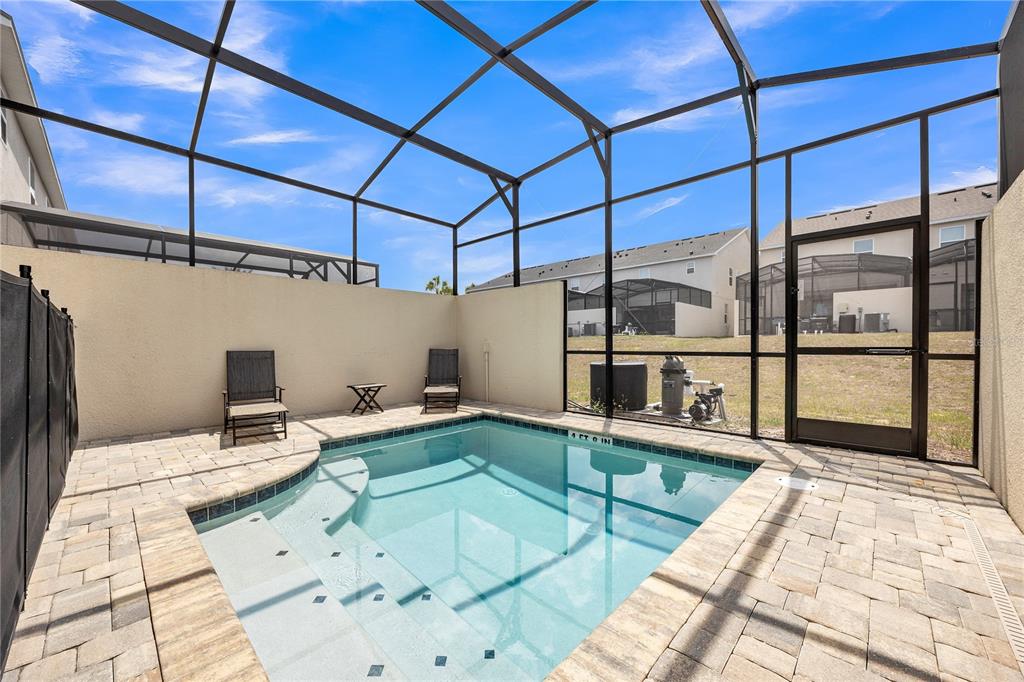 A screened-in patio features a small rectangular swimming pool with steps and paver decking — 2362 ZABALLINA PLACE, KISSIMMEE, FL