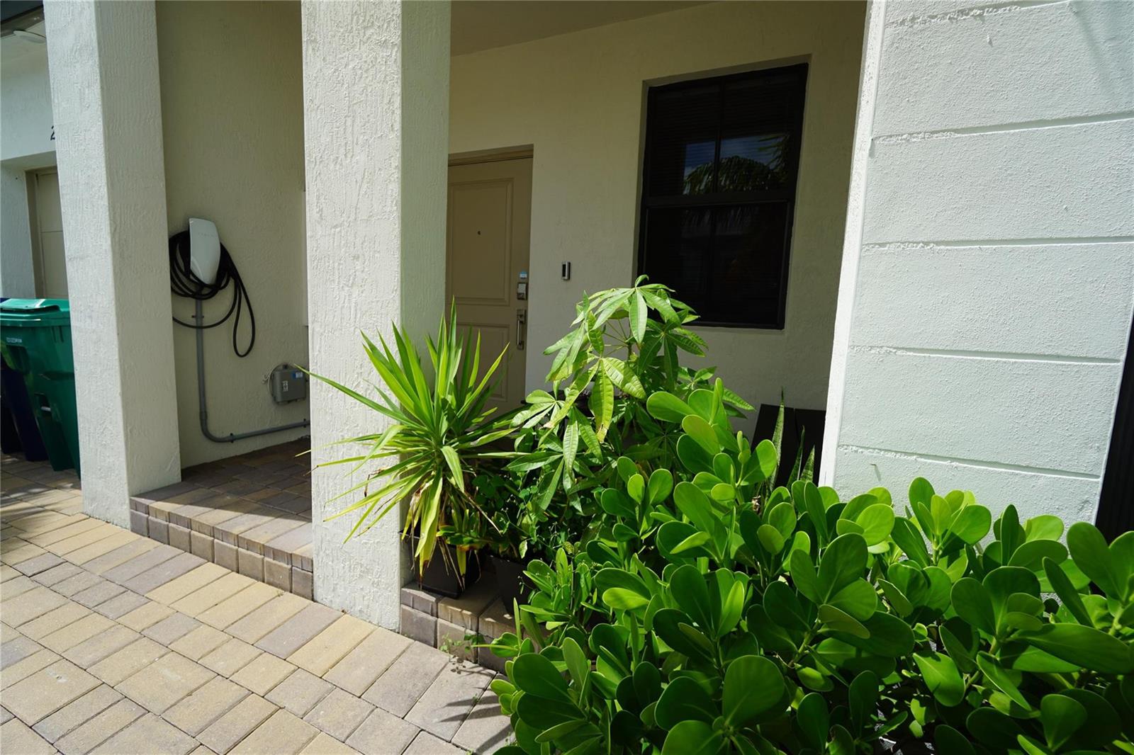 A paved walkway leads to a covered entryway with a door, window, and potted plants — 23010 SW 128th Place # 23010, Miami FL 33170, MIAMI, FL