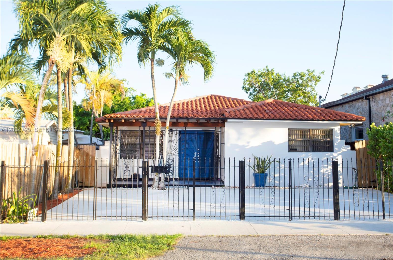 A single-story house with a tiled roof, blue double doors, and a front metal fence — 3610 SW 14th St, Miami FL 33145, MIAMI, FL