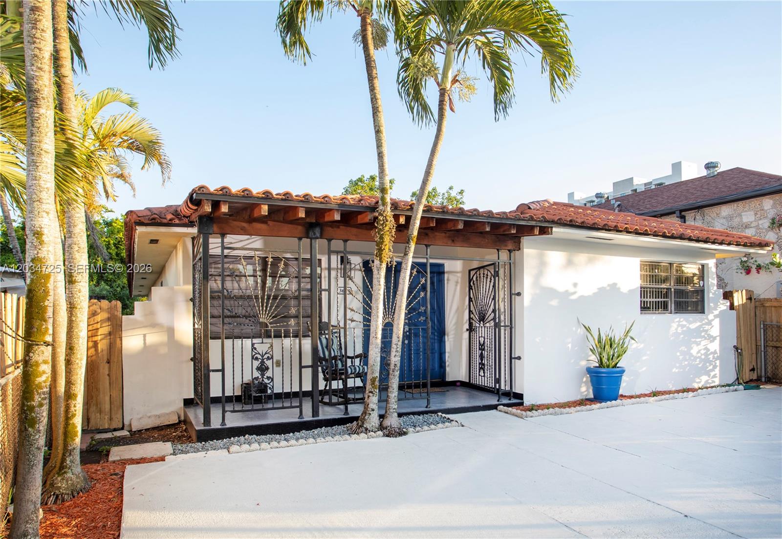 A single-story house features a covered front porch with decorative iron railings and palm trees — 3610 SW 14th St, Miami FL 33145, MIAMI, FL