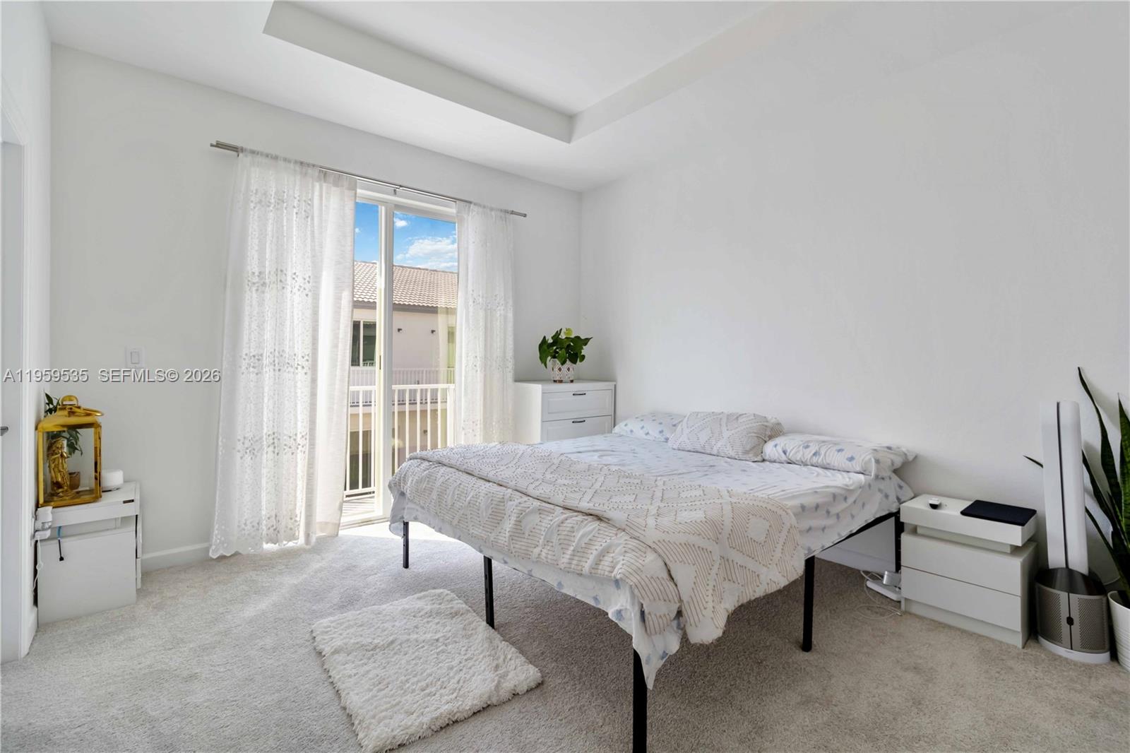 A bedroom with white walls, carpeted flooring, a bed, and a sliding glass door — 760 SE 13th Ct, Homestead FL 33034, HOMESTEAD, FL