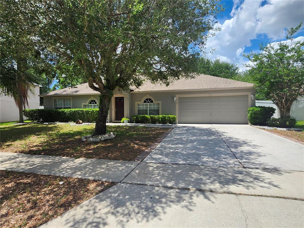 A single-story house with a gray exterior, a two-car garage, and a large front tree — 2200 EL MARRA DRIVE, OCOEE, FL