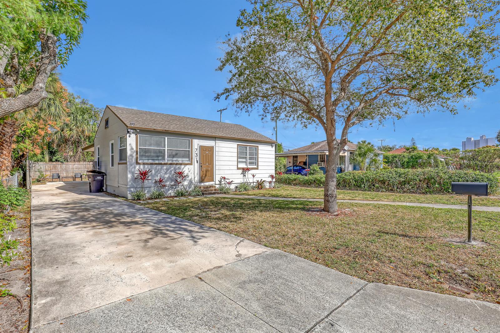 A single-story house with white siding, a brown door, and a concrete driveway — 731 50th Street, West Palm Beach FL 33407, WEST PALM BEACH, FL