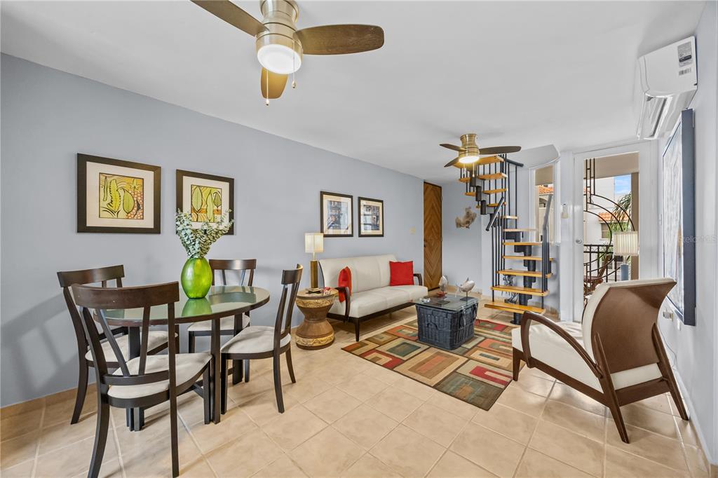 A living and dining room with tile floors, a spiral staircase, and a ceiling fan — 26 CALLE CAMBIJA UNIT PH B-312, RINCON, PR