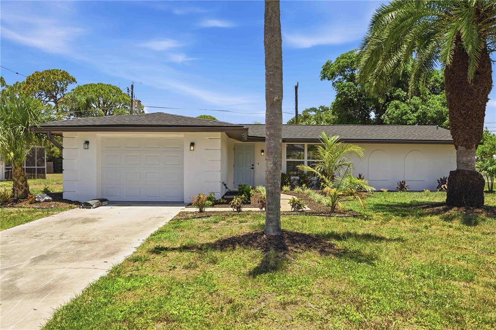 A single-story white house with a one-car garage and a palm tree in the yard — 386 CABANA ROAD, VENICE, FL
