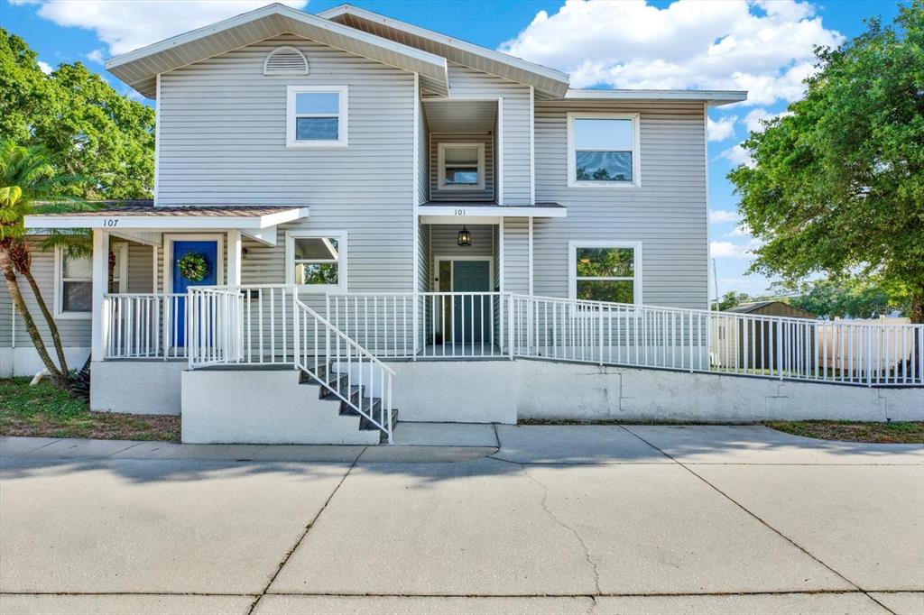 A two-story gray house with a wheelchair ramp, stairs, and two separate entrances — 107 47TH AVENUE N, ST PETERSBURG, FL