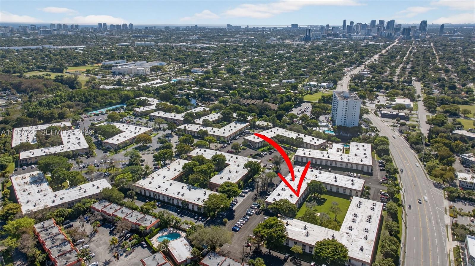 An aerial view shows a multi-building apartment complex with parking lots and surrounding greenery — 9 NE 19th Ct # 104C, Wilton Manors FL 33305, WILTON MANORS, FL