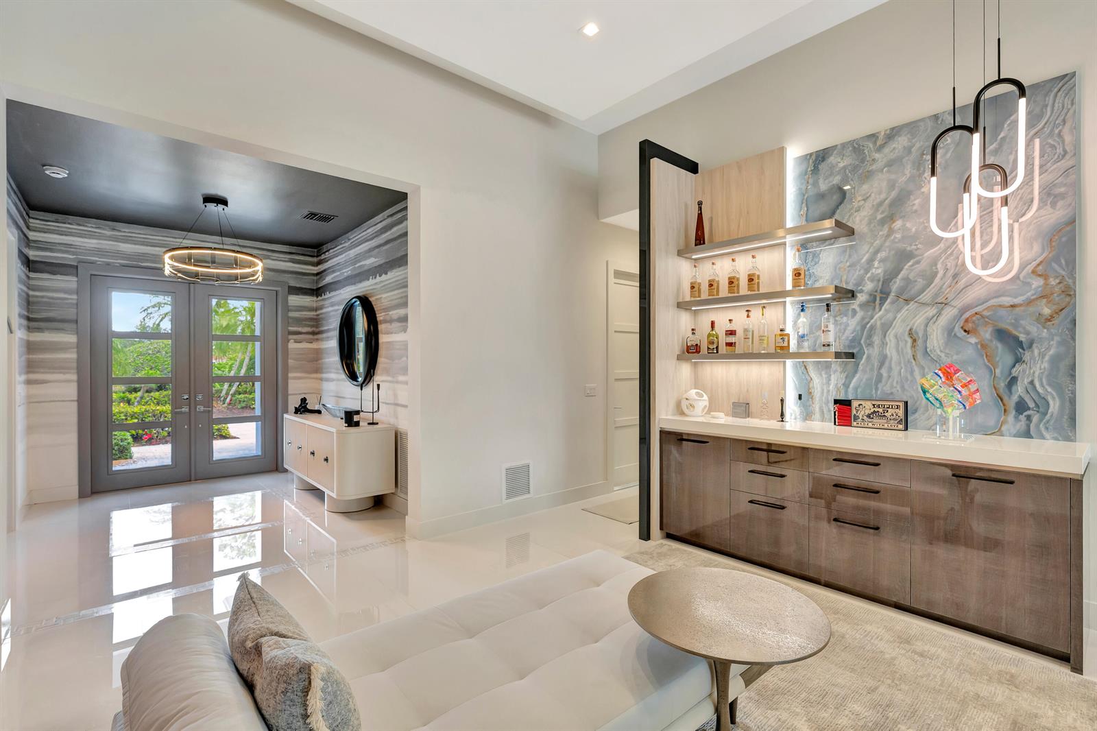 A modern home interior featuring a bar area with stone backsplash and a glass-paned entryway — 124 Golf Village Boulevard, Jupiter FL 33458, JUPITER, FL