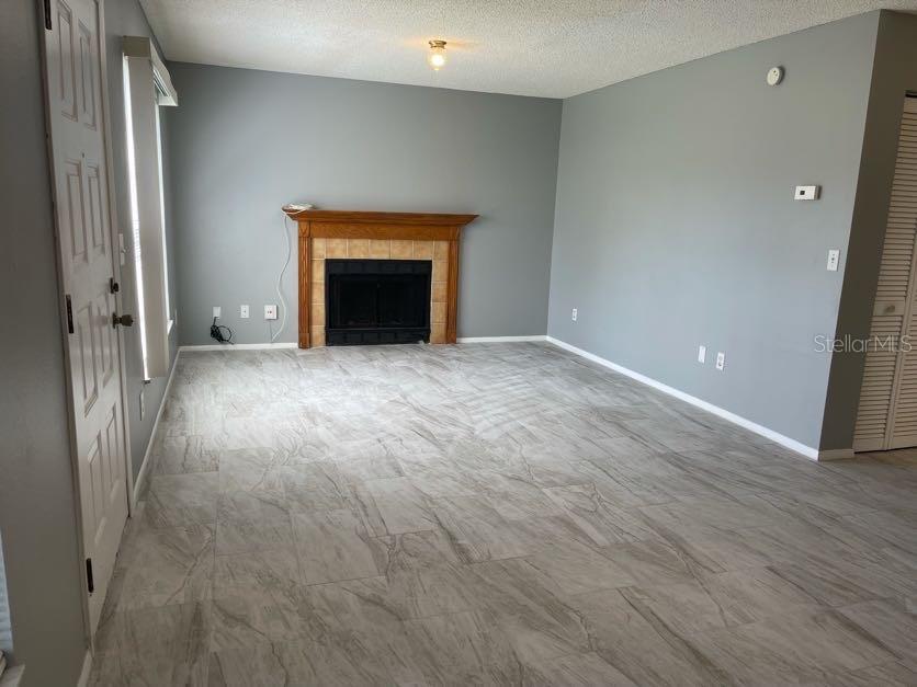 A living room features gray walls, light-colored tile flooring, and a wood-mantel fireplace — 1004 NORTHLAKE DRIVE UNIT 1004, SANFORD, FL