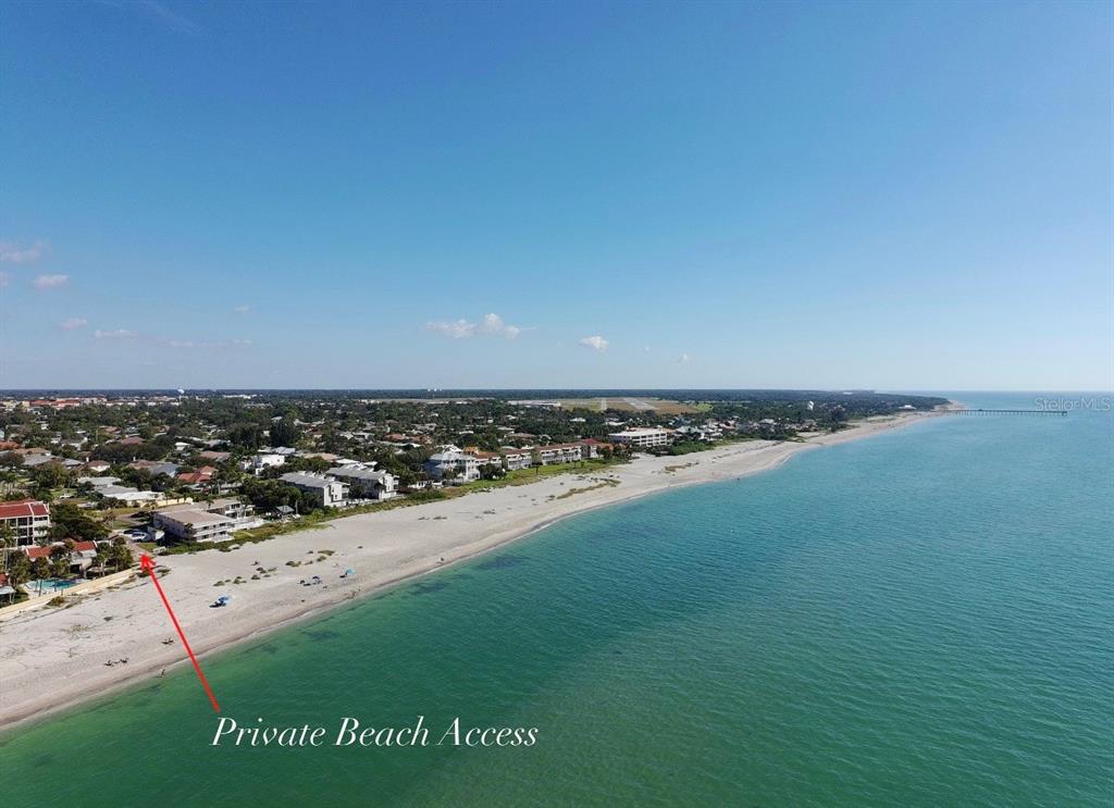 An aerial view of a sandy beach coastline with residential buildings and private beach access — 702 HIBISCUS DRIVE, VENICE, FL