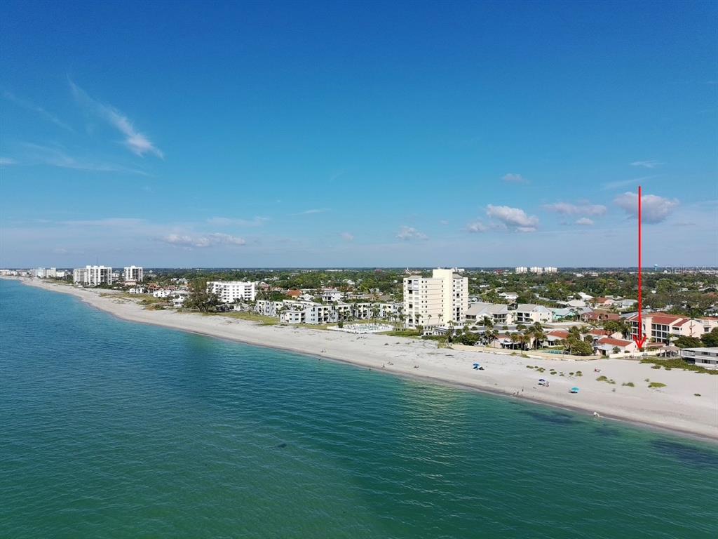 An aerial view shows a sandy beach along the ocean with coastal buildings and resorts — 702 HIBISCUS DRIVE, VENICE, FL