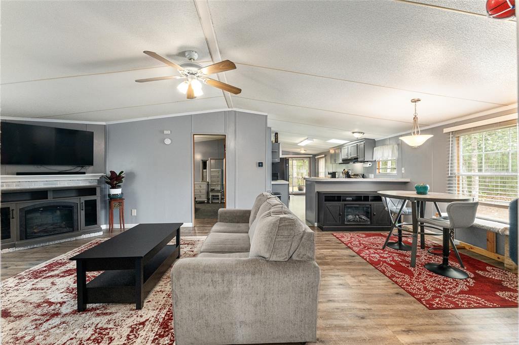 An open-concept living and dining area features gray walls, wood-look flooring, and two fireplaces — 1504 NW 156TH AVENUE, GAINESVILLE, FL