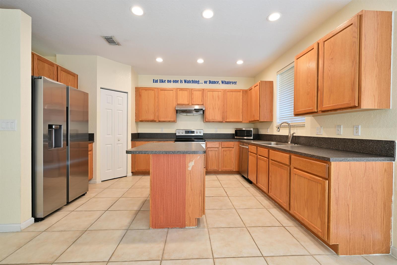 A kitchen with light wood cabinets, stainless steel appliances, a center island, and tile flooring — 2789 S Evergreen Circle, Boynton Beach FL 33426, BOYNTON BEACH, FL