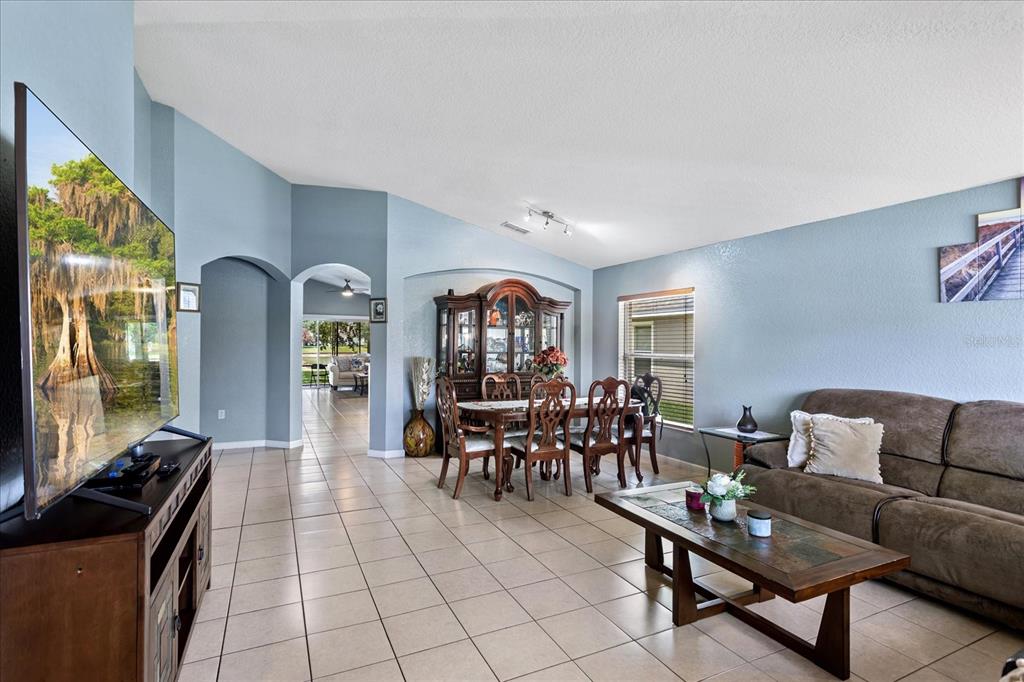 A living and dining room with light blue walls, tile flooring, and a brown sofa — 2886 OCONNELL DRIVE, KISSIMMEE, FL