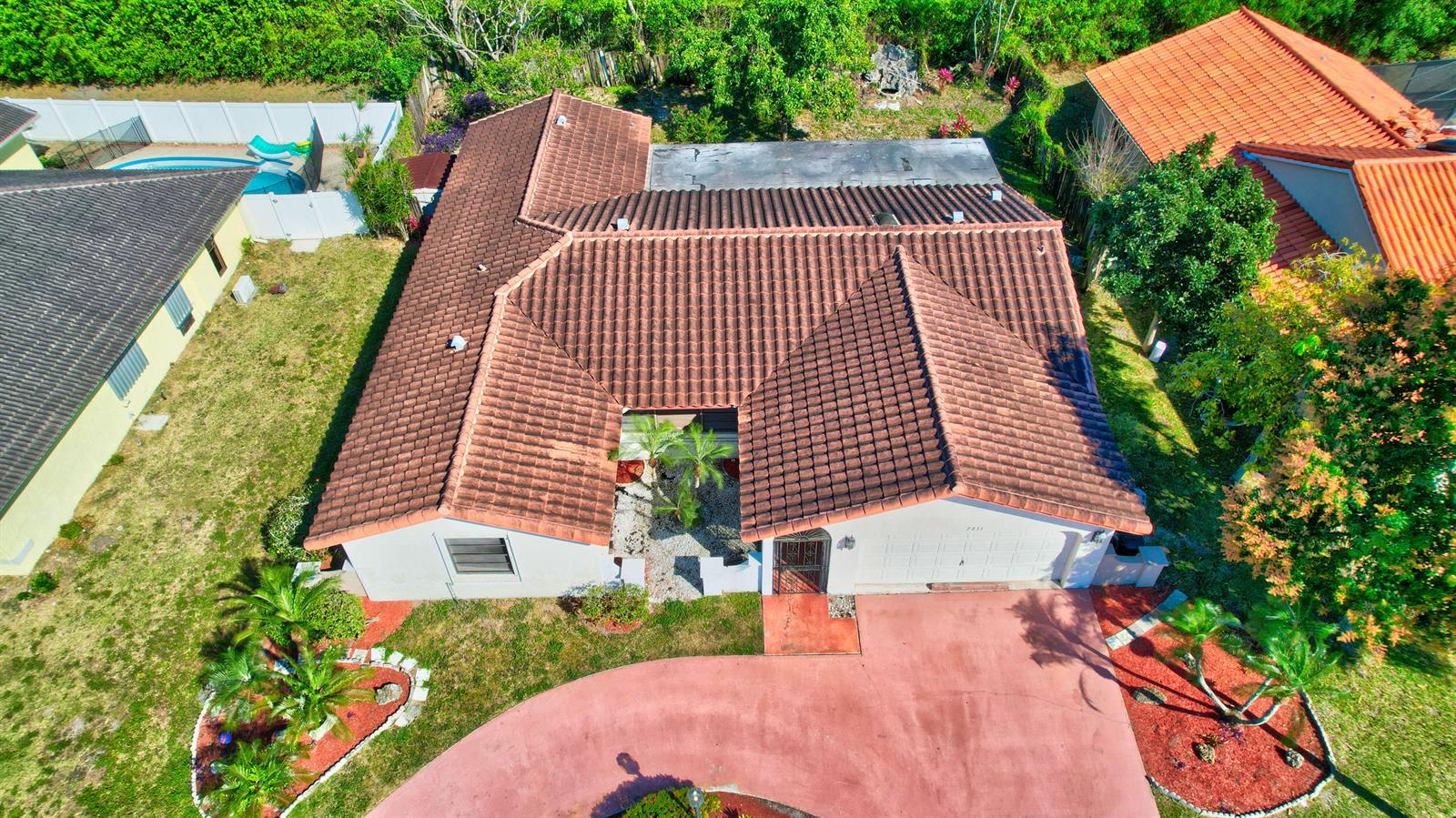 An aerial view shows a single-story house with a brown tile roof and driveway — 7011 San Sebastian Circle, Boca Raton FL 33433, BOCA RATON, FL