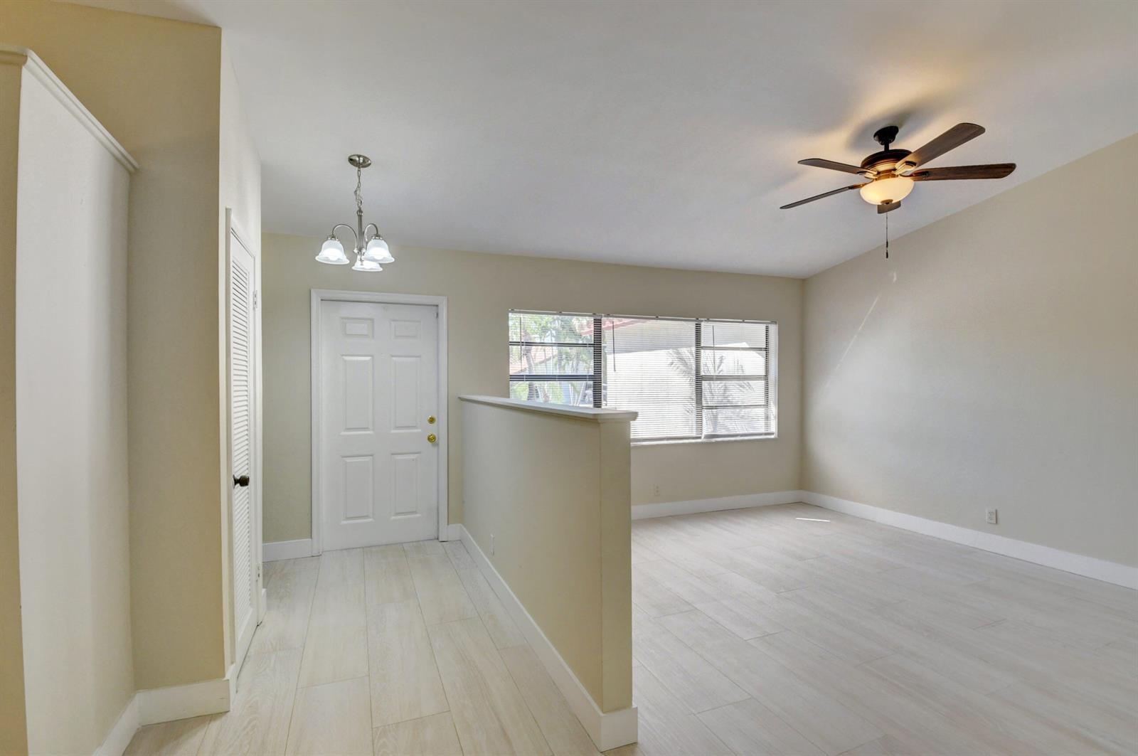 A room with light-colored tile flooring, a ceiling fan, and a half-wall partition — 7011 San Sebastian Circle, Boca Raton FL 33433, BOCA RATON, FL