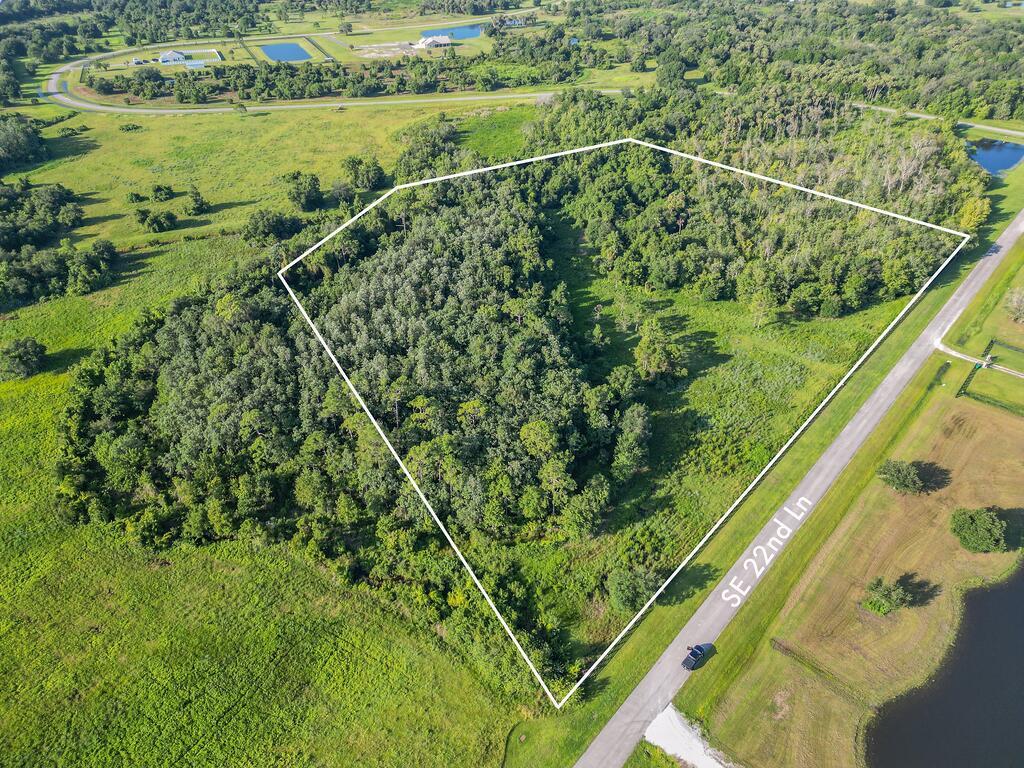 An aerial view shows a wooded plot of land outlined in white next to a road — 13520 SE 22nd Lane, Okeechobee FL 34974, OKEECHOBEE, FL