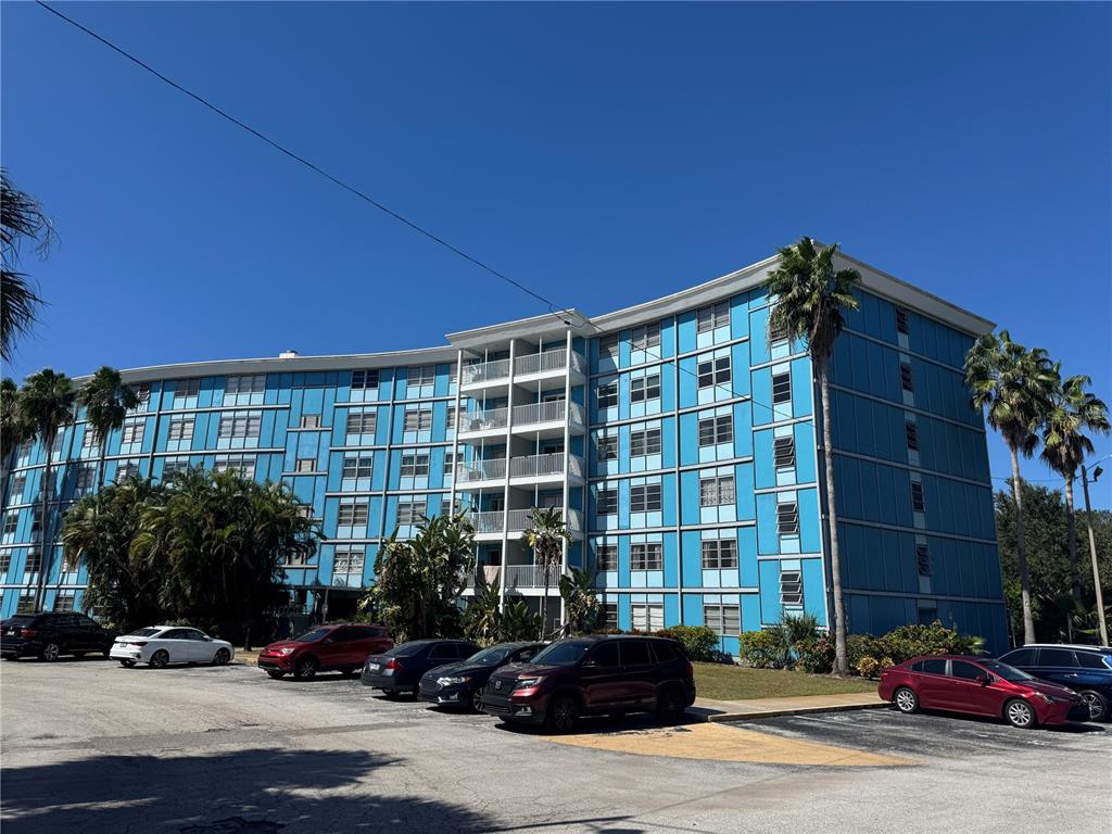 A multi-story blue apartment building with balconies and a parking lot in front — 3315 58TH AVENUE S UNIT 201, ST PETERSBURG, FL