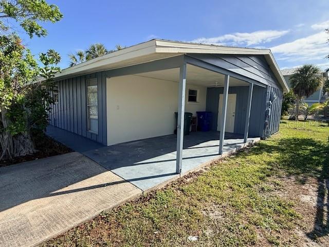 A side view of a house with a covered carport and a concrete driveway — 600 RUSSELL STREET, LONGBOAT KEY, FL