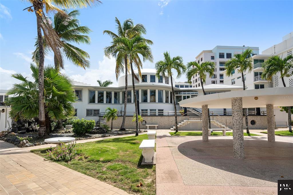 Exterior view of a white building with palm trees, a patio, and a covered pavilion — 20 AMAPOLA STREET, CAROLINA, PR