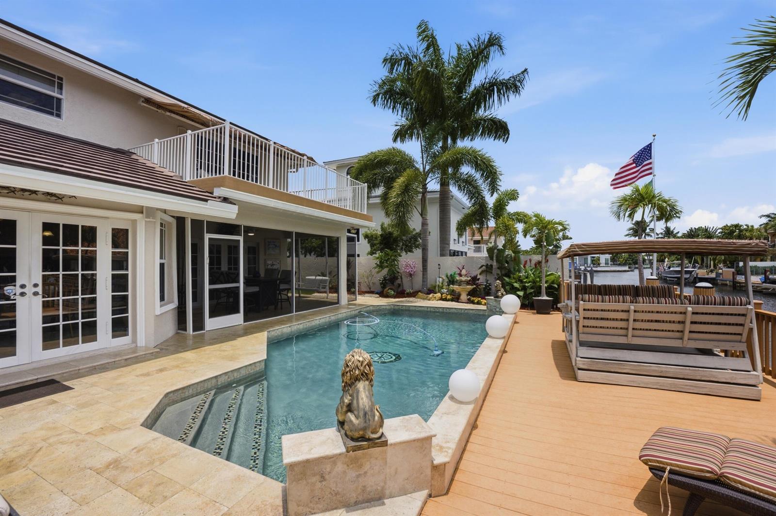 A backyard features a swimming pool, stone patio, wooden deck, and a waterfront view — 1548 SW 5th Avenue, Boca Raton FL 33432, BOCA RATON, FL