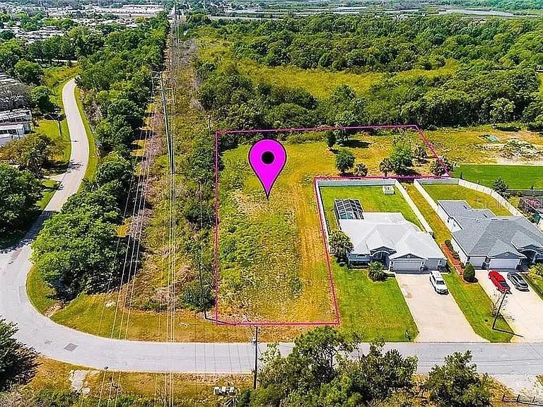 An aerial view shows a vacant residential lot outlined in pink next to two houses — 0 N JASMINE AVENUE, TARPON SPRINGS, FL